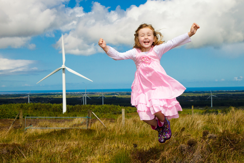 Child playing near wind farm